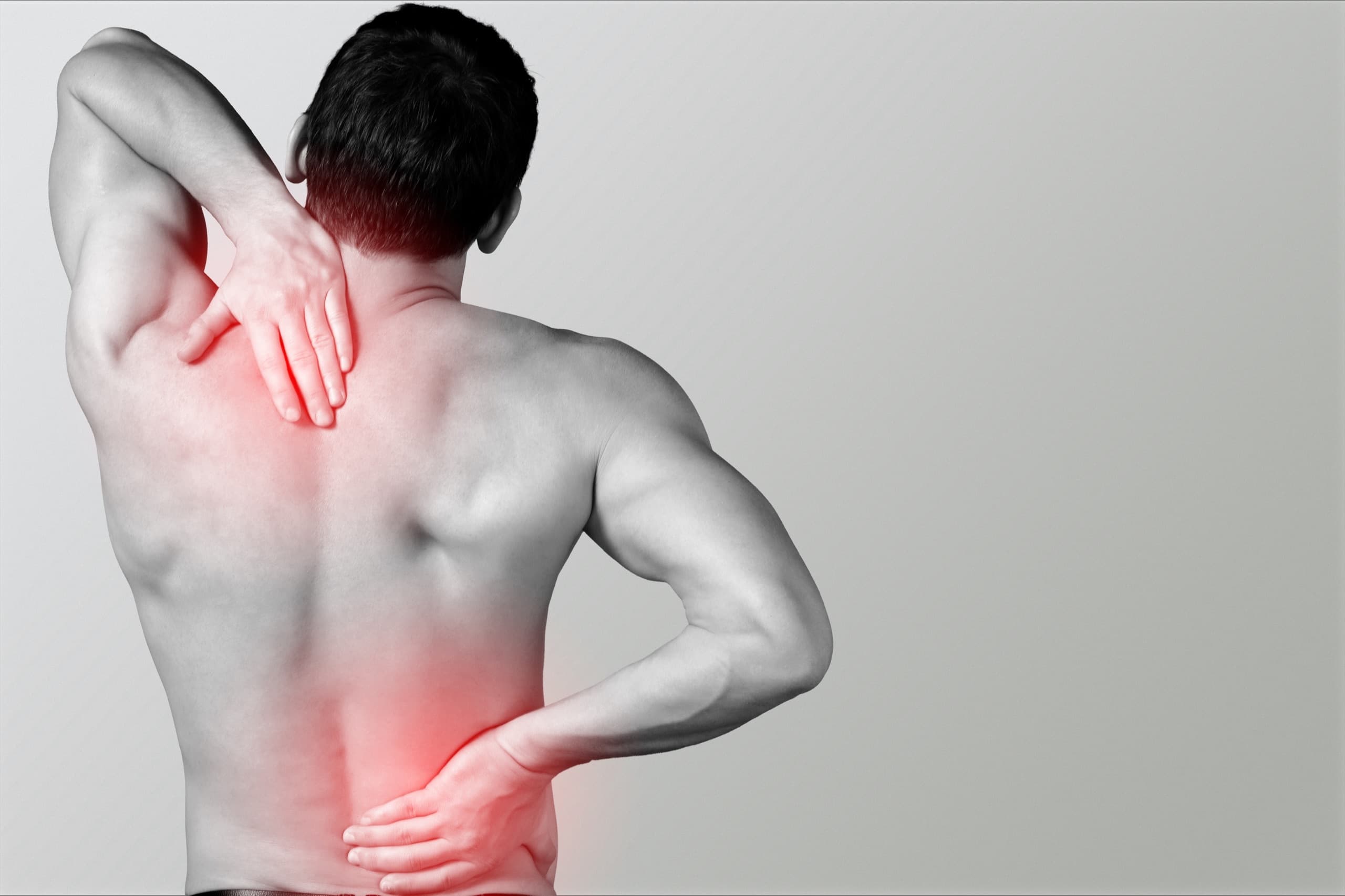 Man holding his neck and lower back with radiating pain